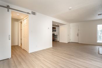 A room with a sliding door and a kitchen